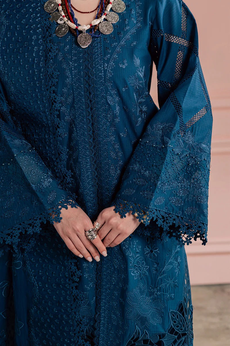 Blue embroidered dress with intricate patterns and a necklace.