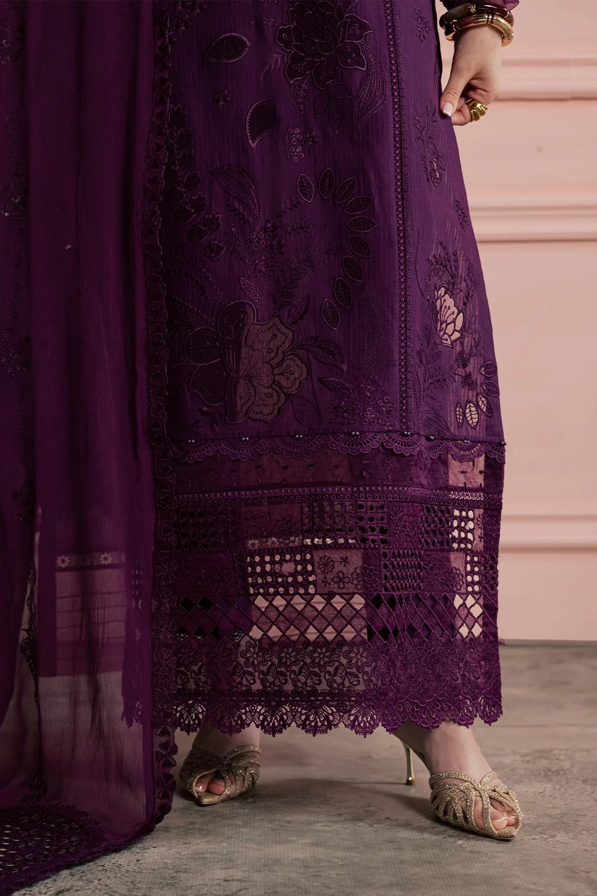 Purple embroidered dress with intricate patterns on a neutral background