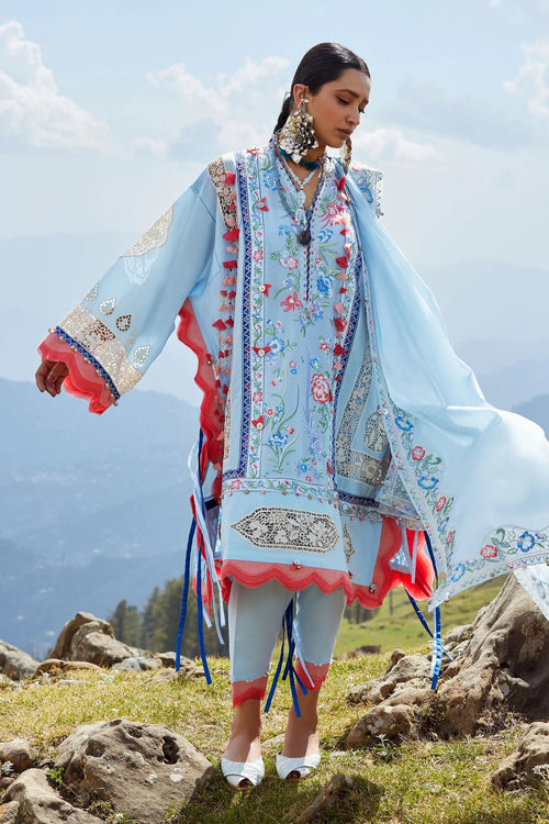 Woman in traditional embroidered outfit standing on a mountainous landscape