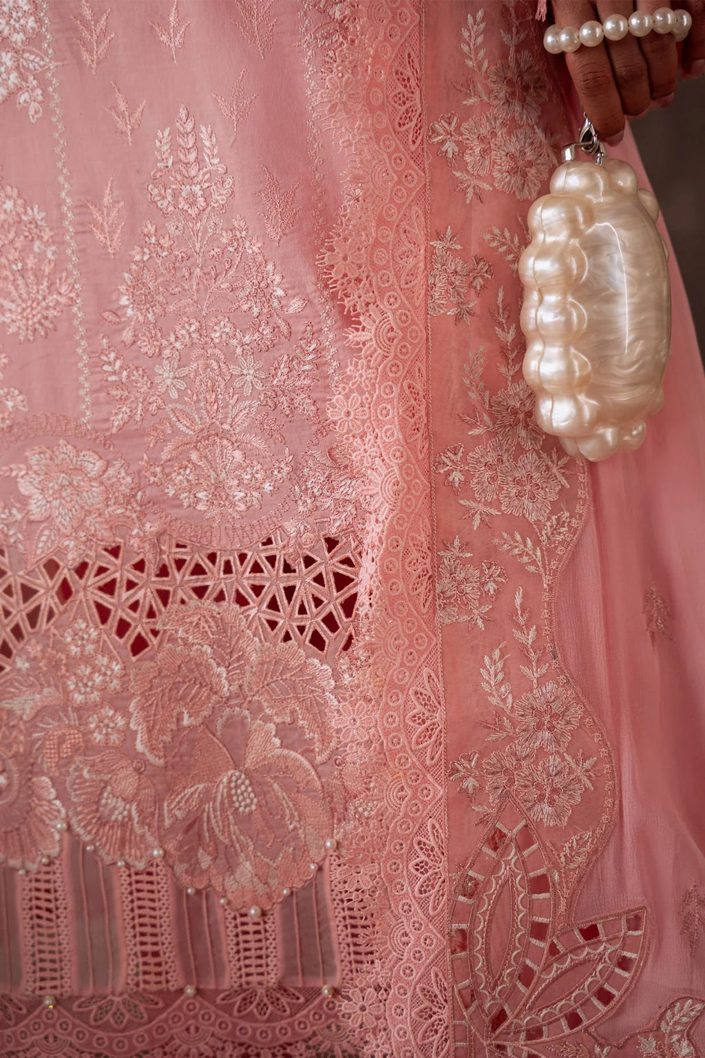 Close-up of a pink embroidered fabric with a decorative pearl holder.