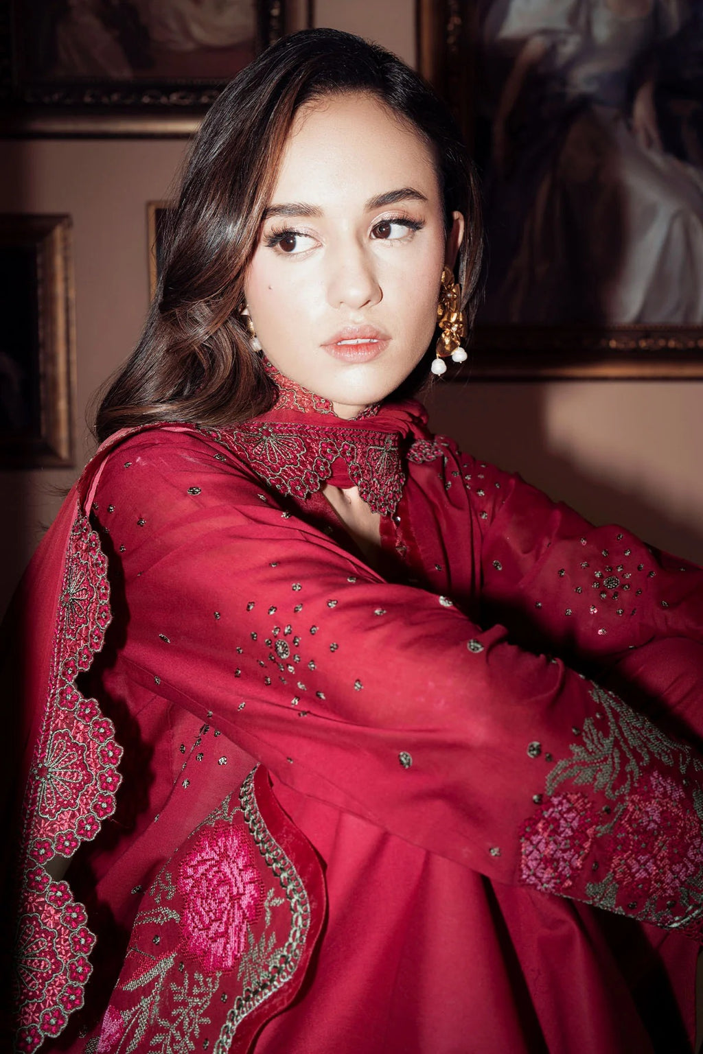 Woman wearing a red embroidered traditional outfit with a blurred background