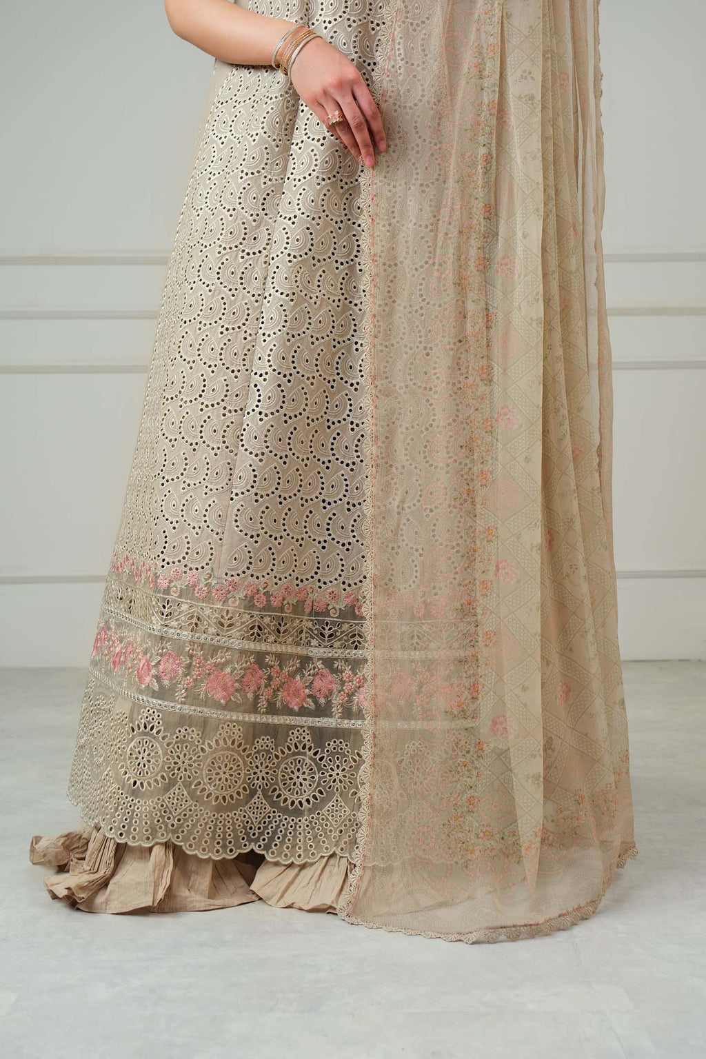Beige embroidered traditional dress on a plain background