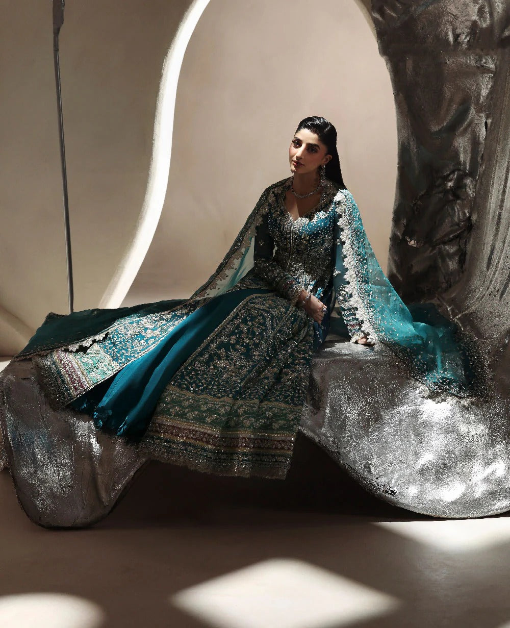 Woman in traditional attire sitting on a decorative stone bench.