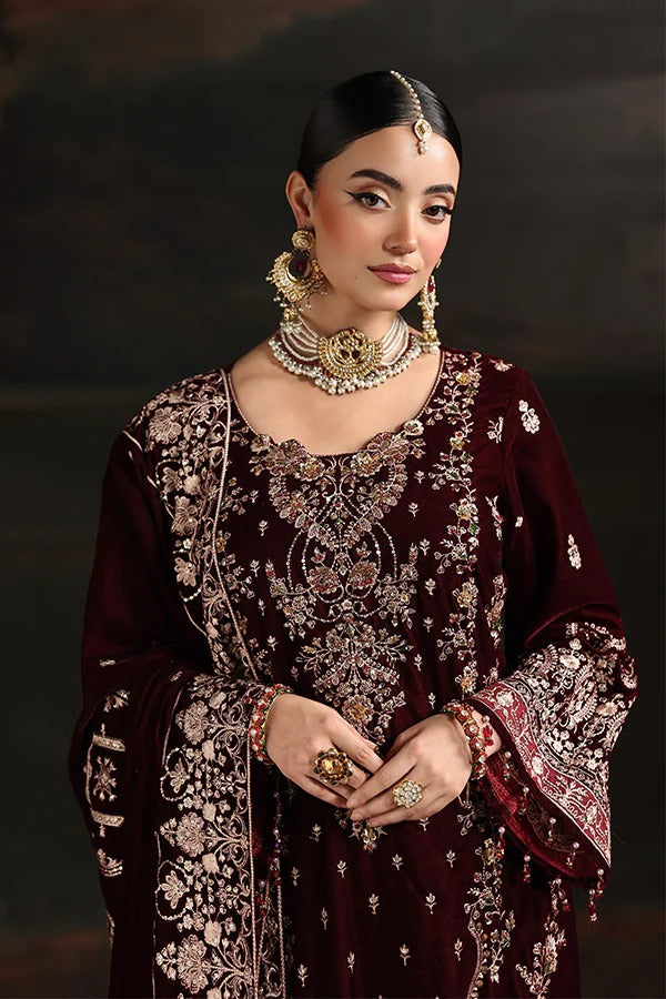 Woman in traditional embroidered outfit with jewelry against a dark background