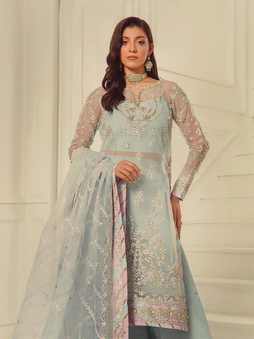 Woman wearing a light blue embroidered traditional outfit with a white background