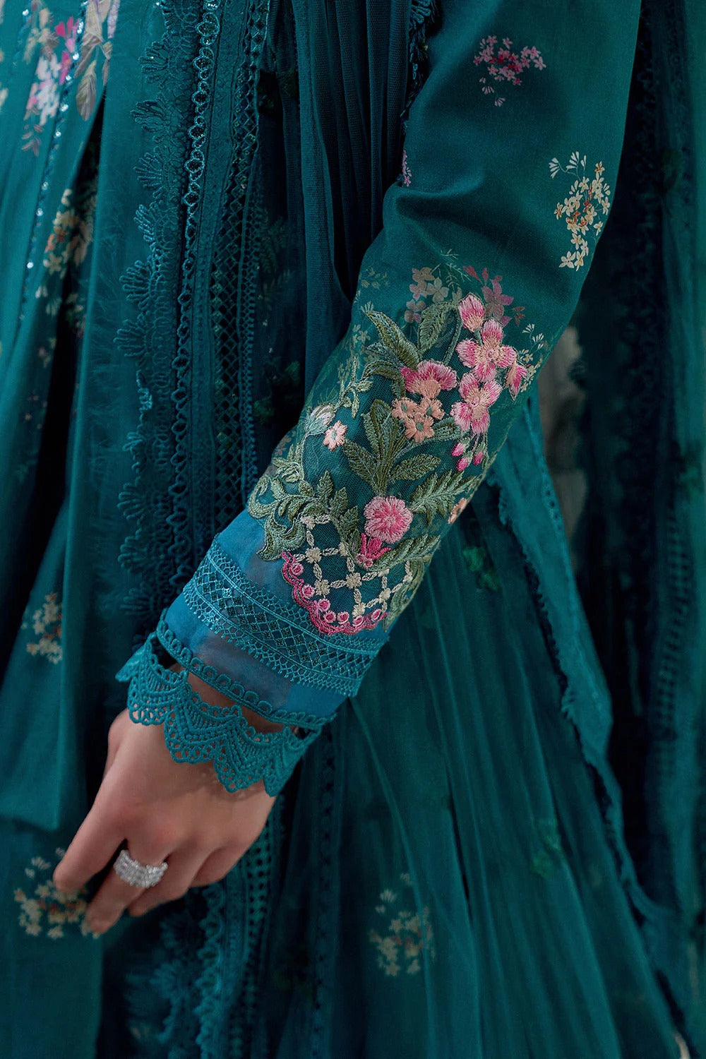 Close-up of a teal embroidered garment with floral patterns