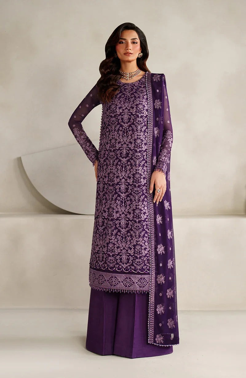 Woman wearing a purple embroidered outfit with a matching dupatta against a neutral background
