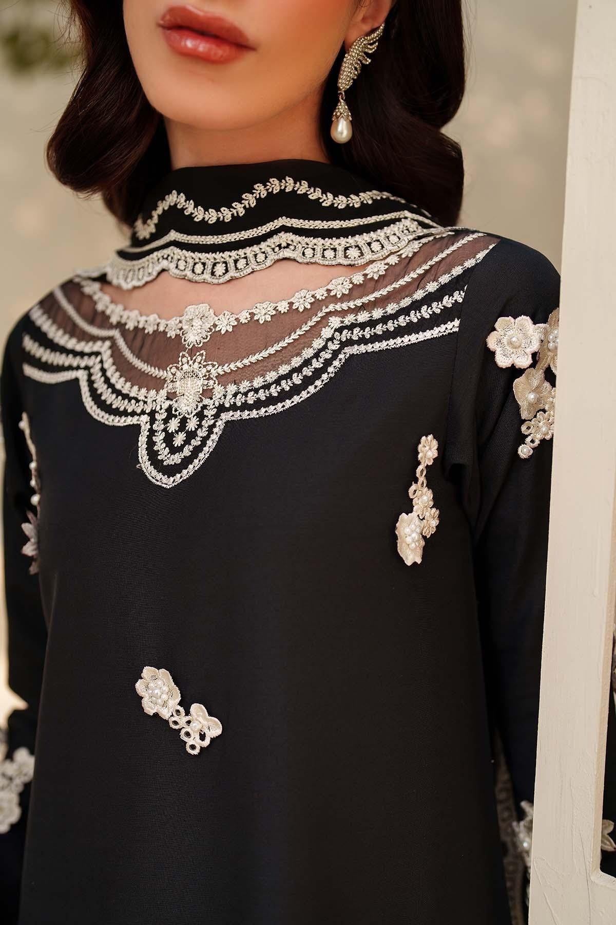 Black outfit with intricate white embroidery and embellishments
