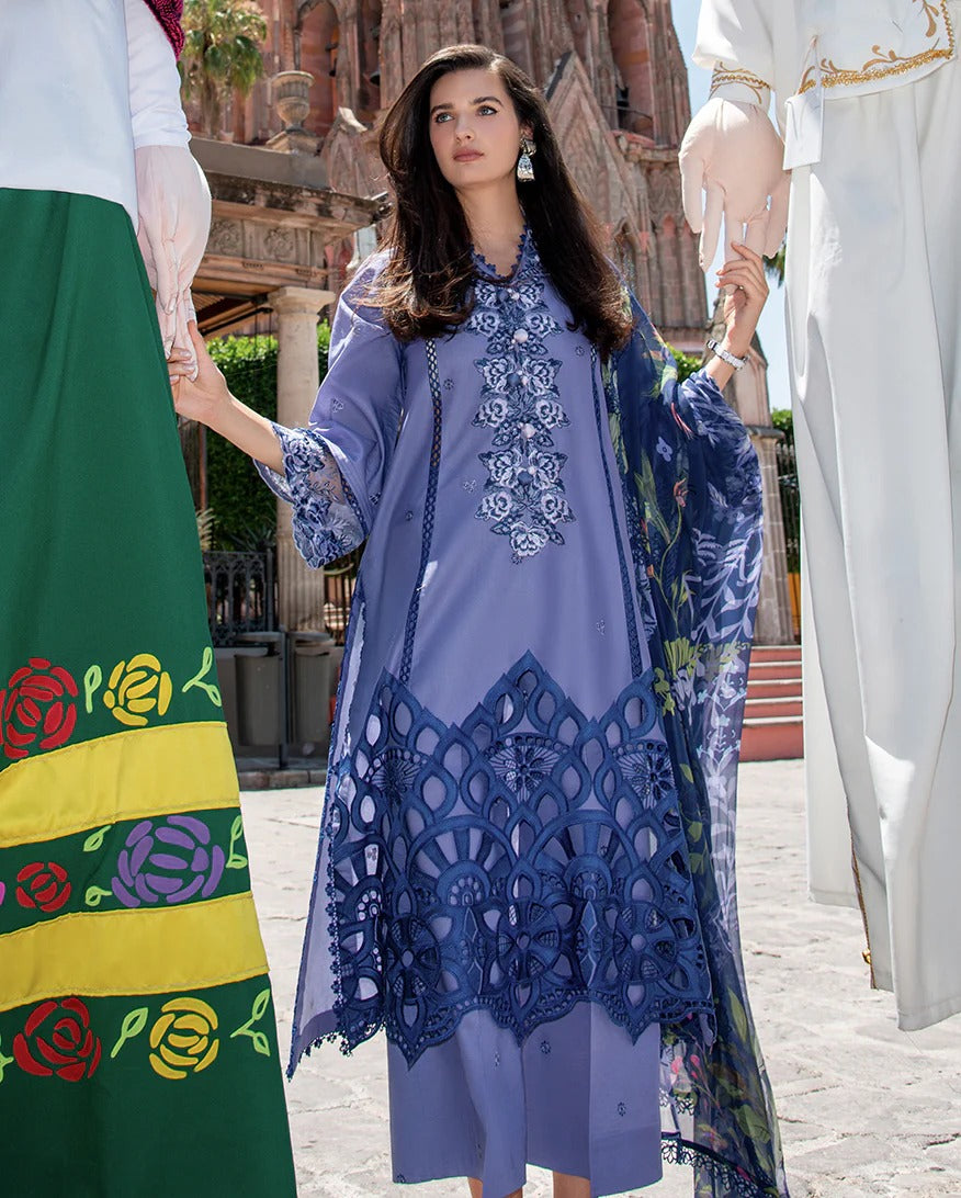 Woman in a blue embroidered dress standing outdoors with a blurred background