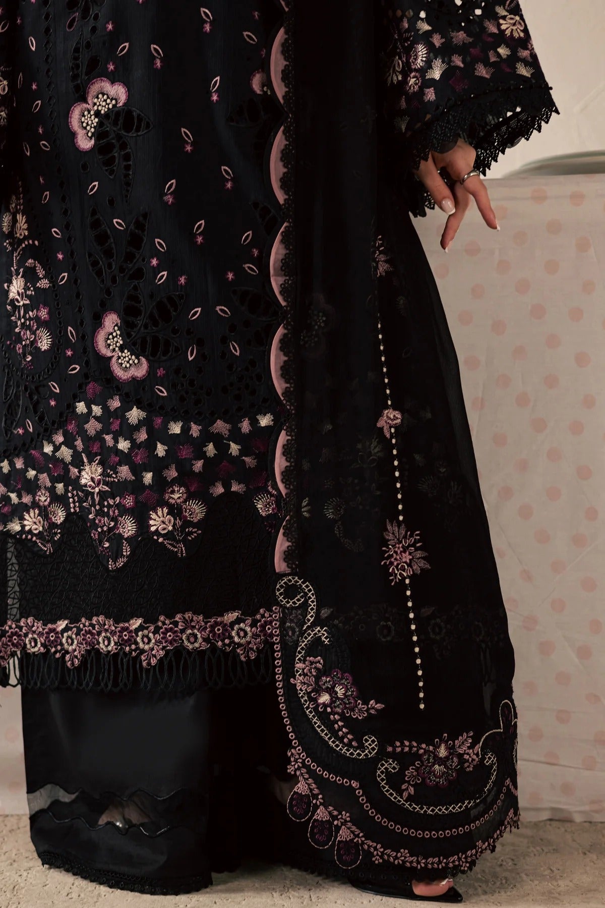 Black embroidered abaya with floral patterns on a neutral background