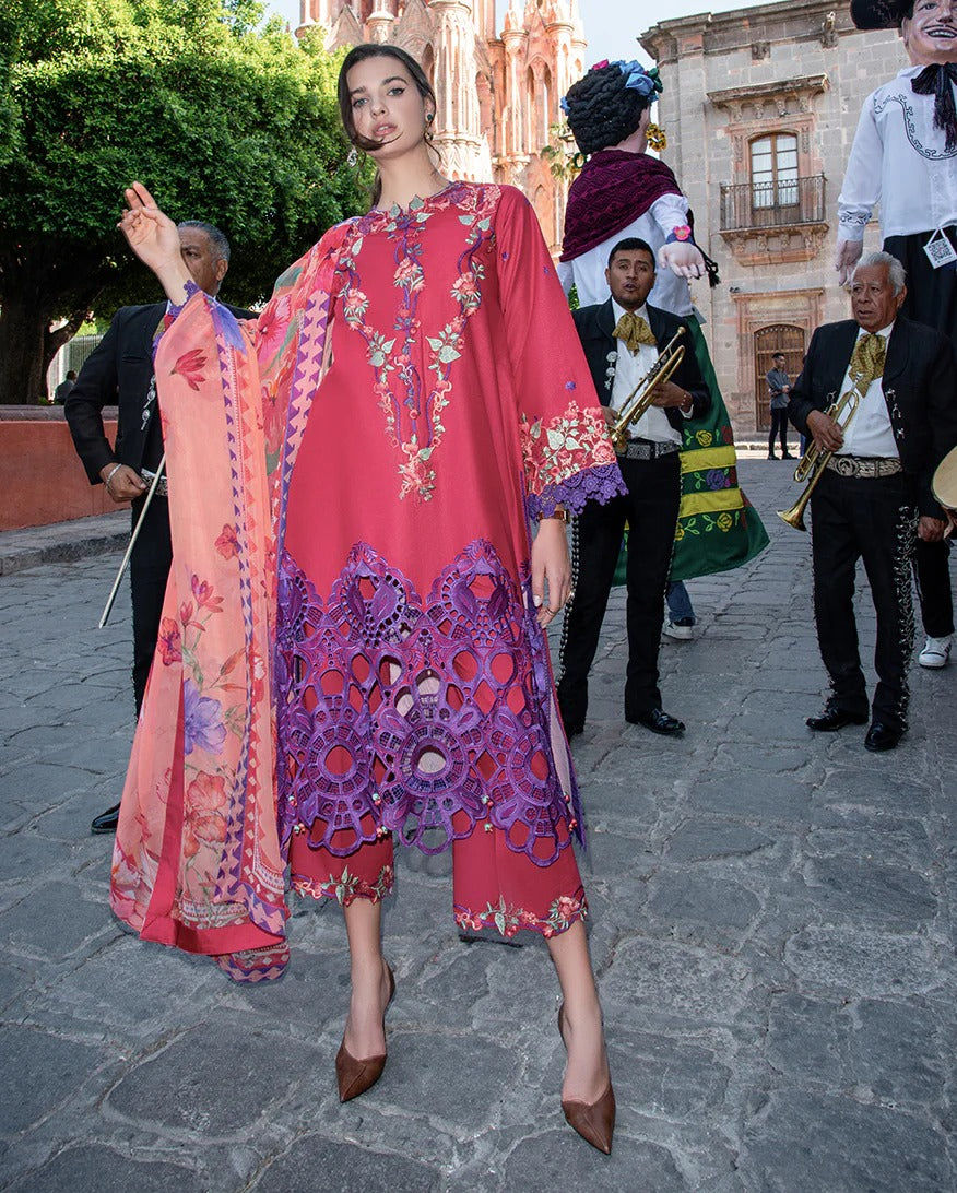 Woman in a colorful dress with intricate patterns standing on a street with musicians in the background.