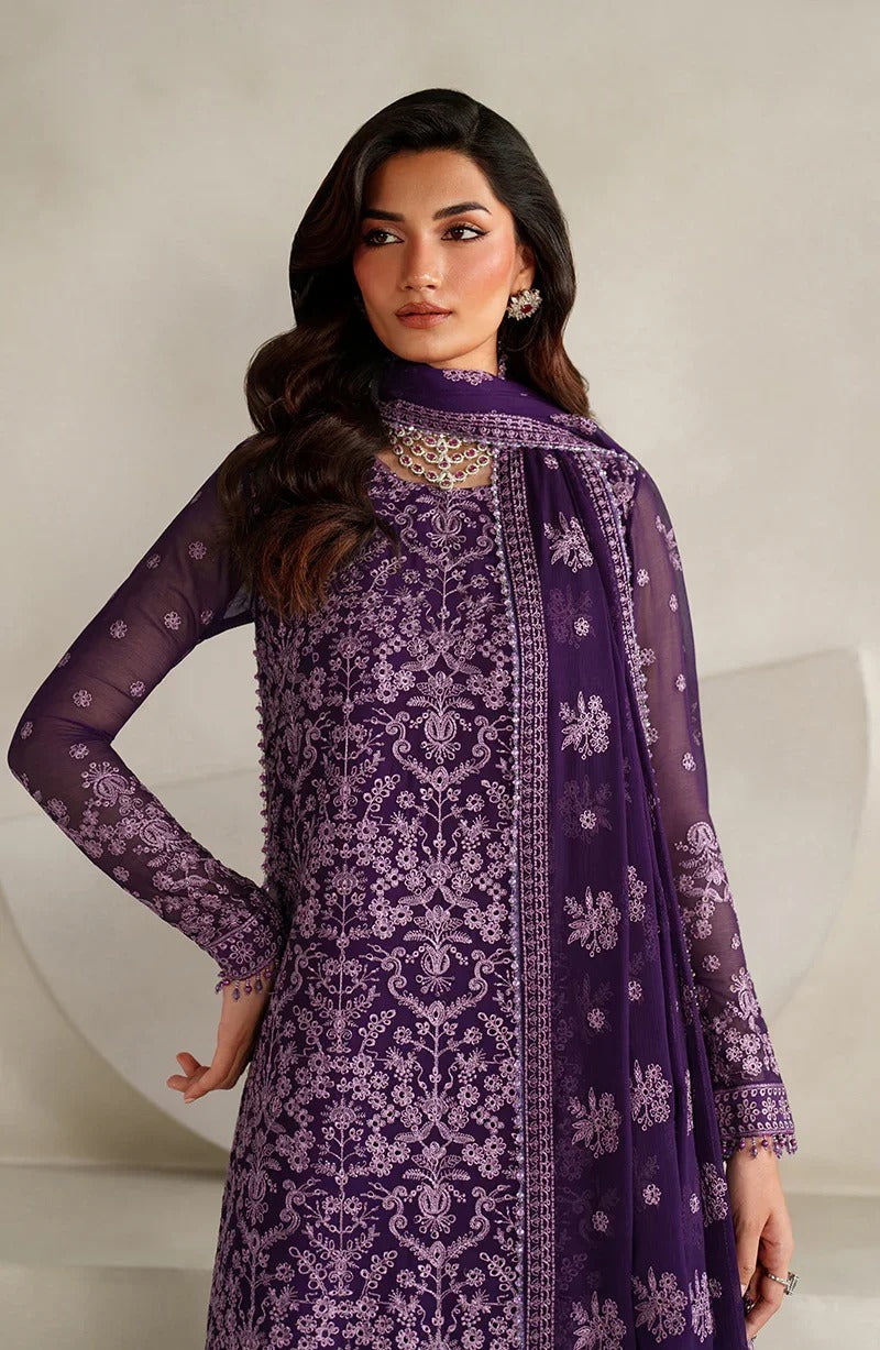 Woman wearing a purple embroidered outfit with a matching dupatta against a neutral background
