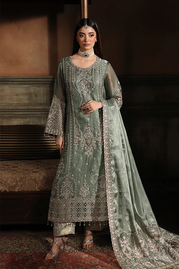 Woman in a traditional embroidered outfit standing in a dimly lit room.