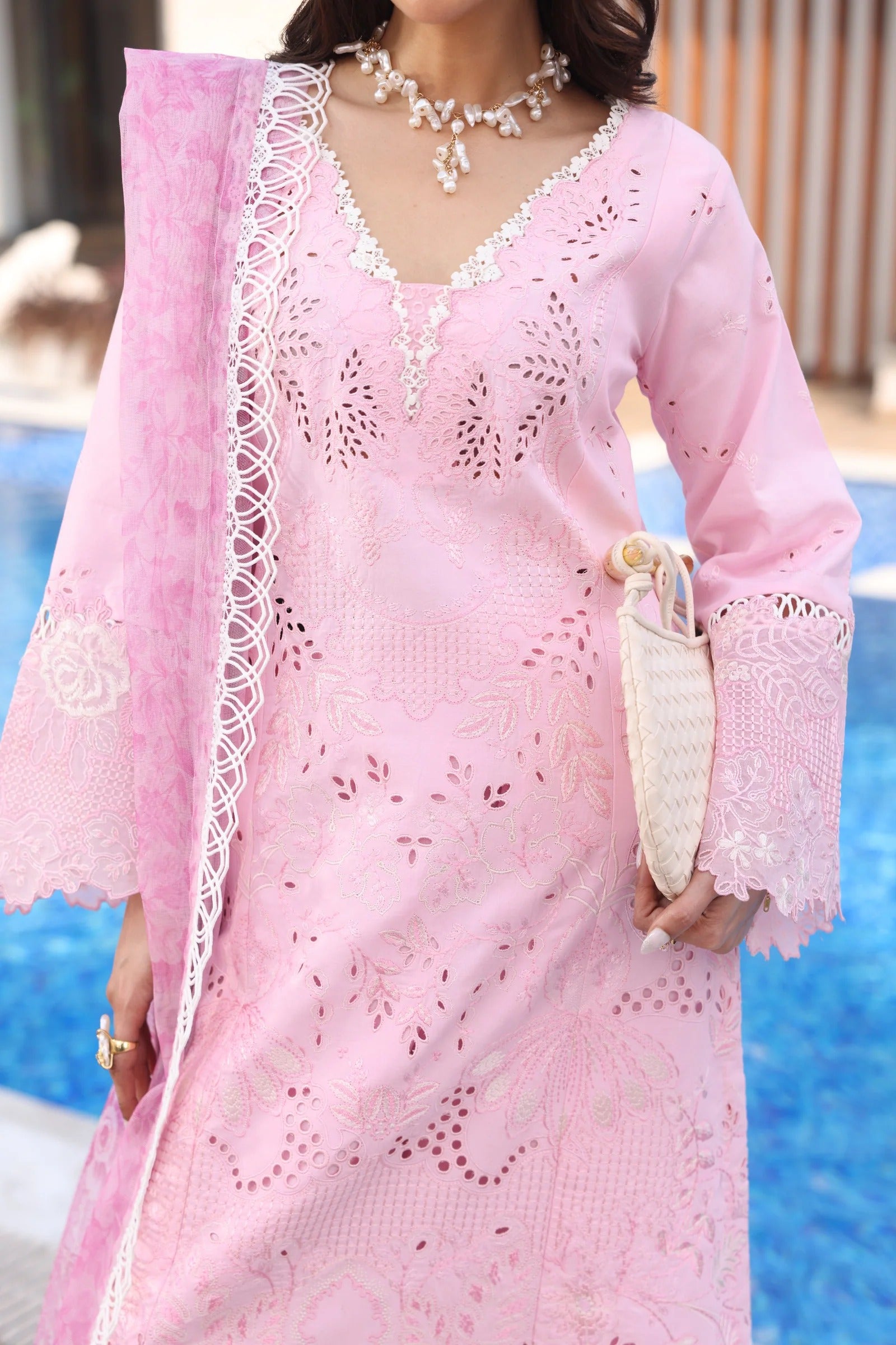 Woman wearing a pink lace dress by a poolside