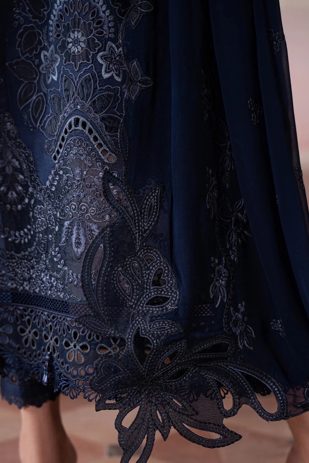 Navy blue dress with intricate lace detailing on a blurred background