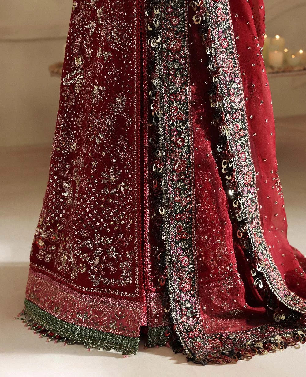 Red embroidered fabric with intricate patterns on a neutral background