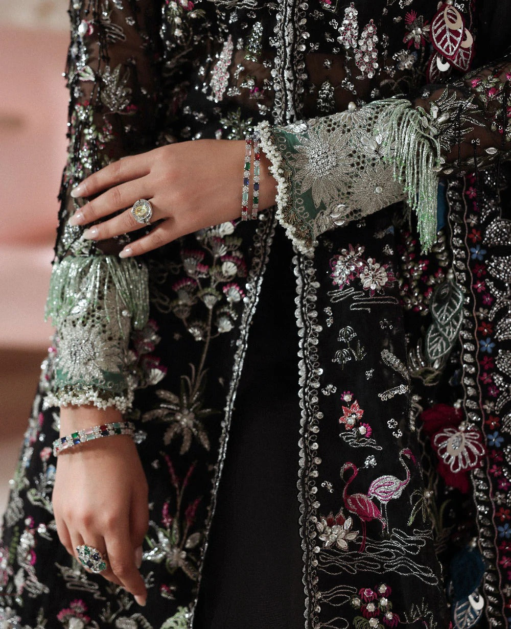 Close-up of a hand holding a decorative clutch with intricate patterns and embellishments.