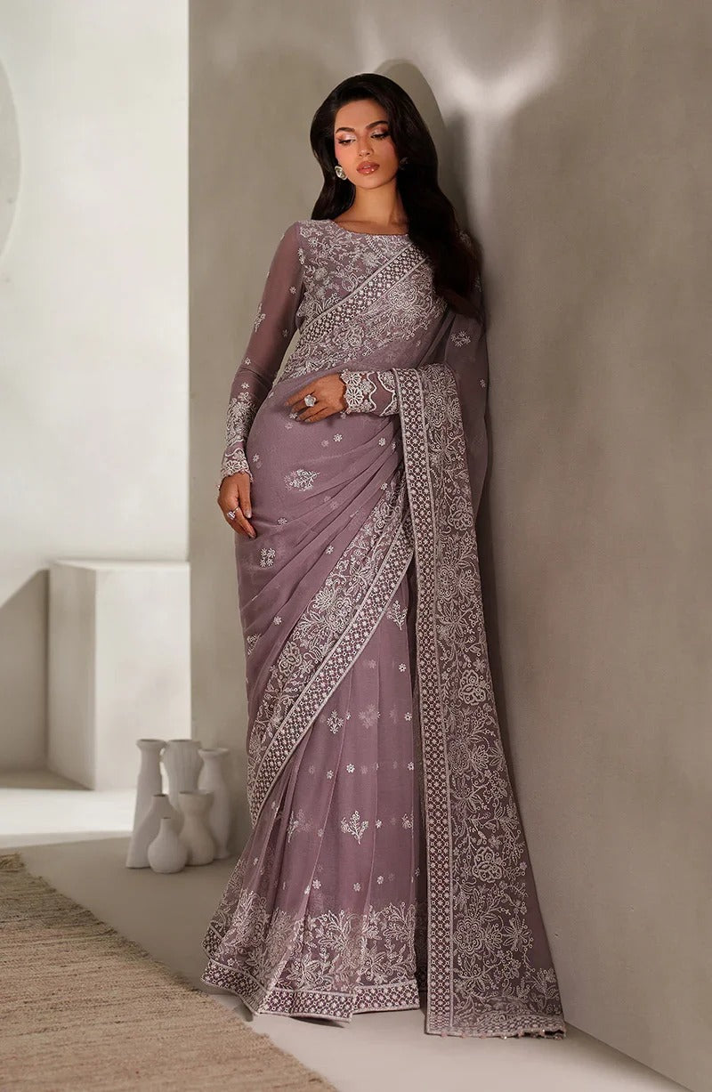 Woman wearing a purple saree with white patterns in a minimalistic setting