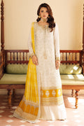Woman wearing a white and yellow traditional outfit in a room with wooden furniture.
