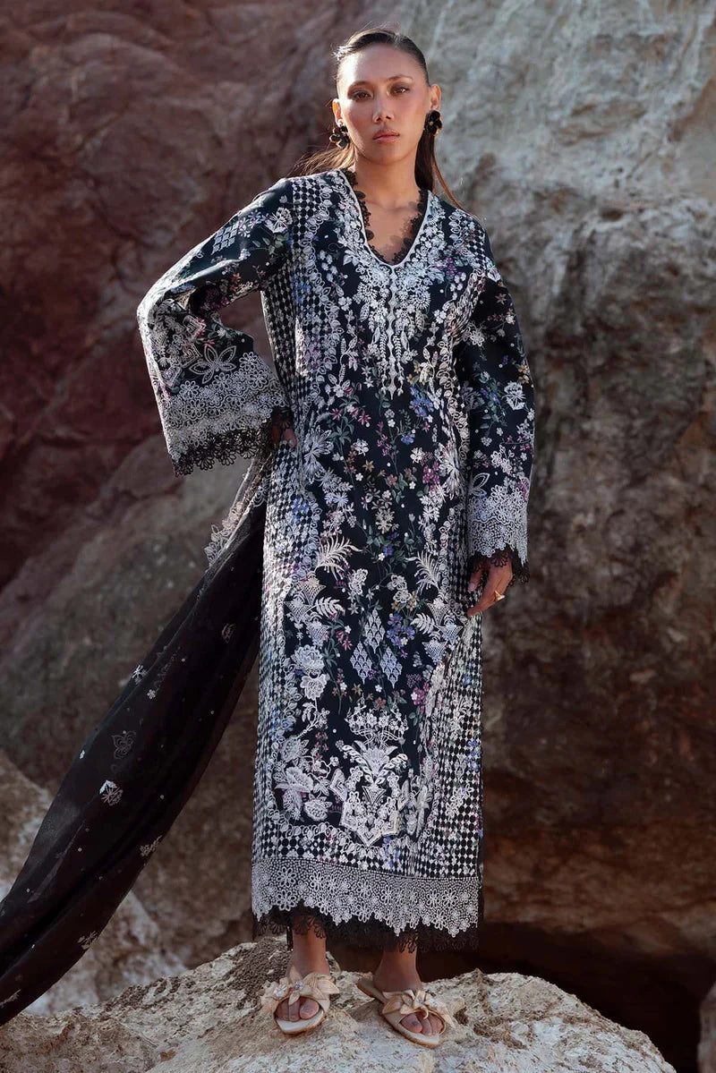 Woman in a patterned dress standing against a rocky background