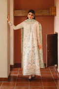 Woman wearing a traditional embroidered outfit in a room with tiled floor and wooden door.